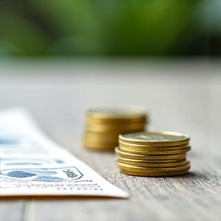 日本の建築物と並んで積み上げられたコインと書類